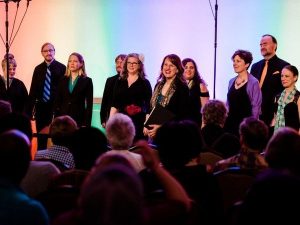 people on stage with colored lights behind them