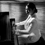 woman playing piano in white suit