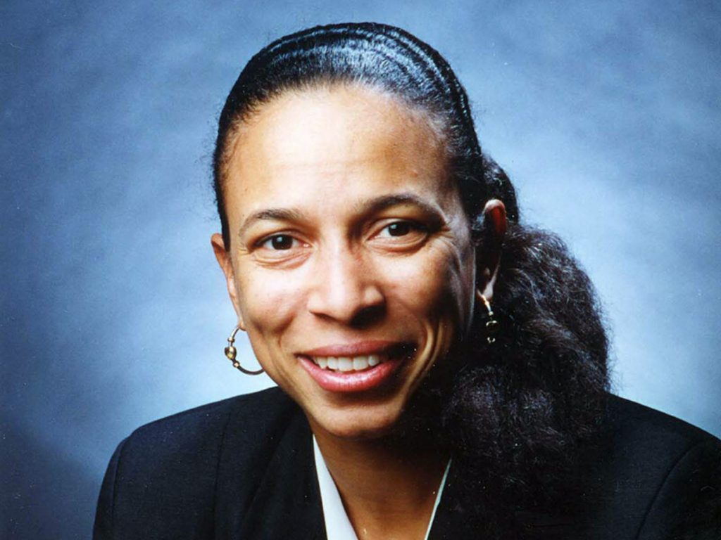 photo of woman smiling at camera with blue background