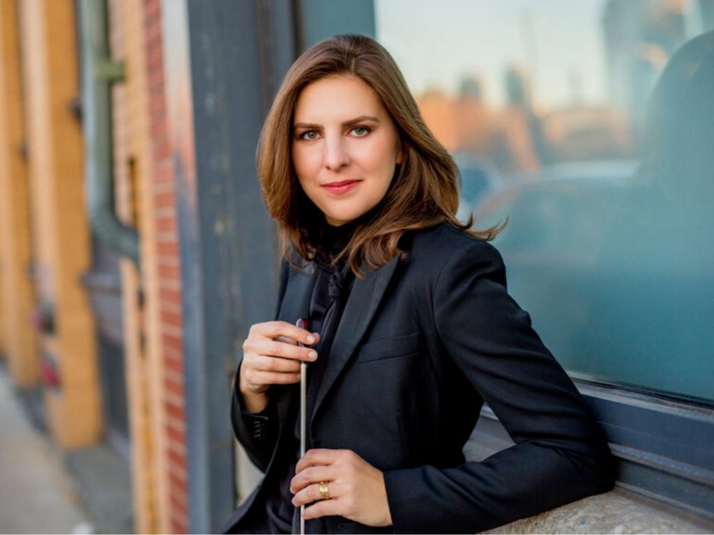 photo of woman with baton leaning against wall