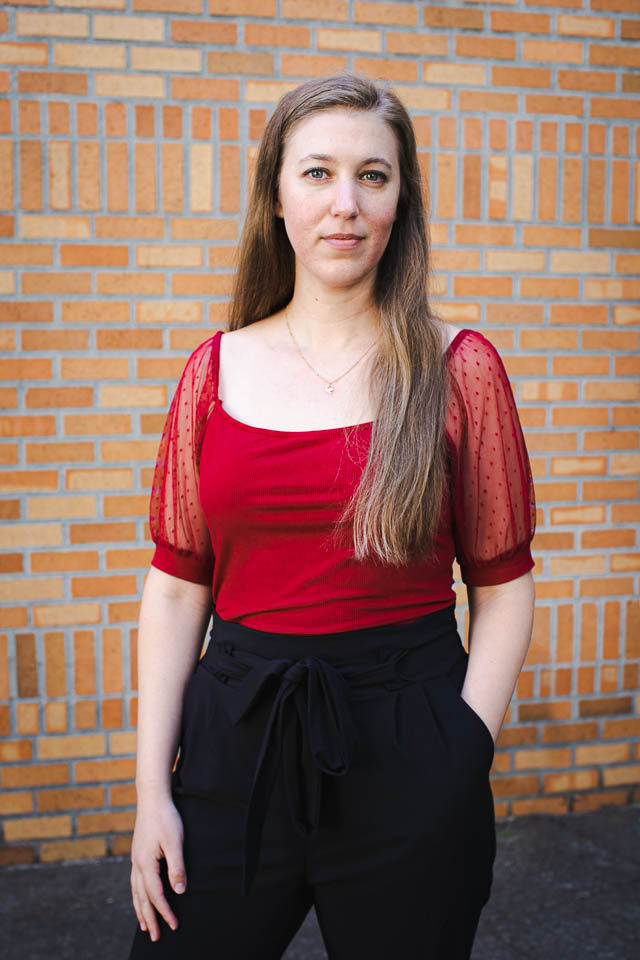 A woman standing in front of a brick wall - Rebecca Richardson