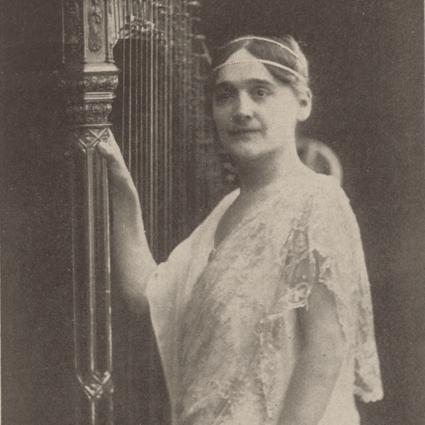Black and white photo of Henriette Renie standing next to a harp