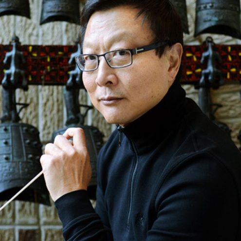 Photo of Bright Sheng holding a conducting baton
