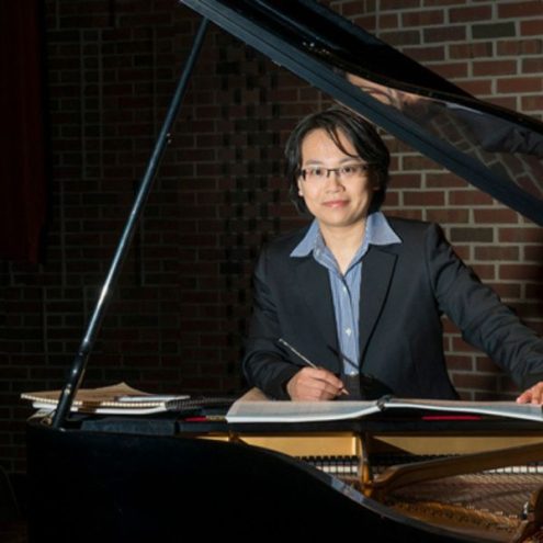 Photo of Chiayu standing behind a piano